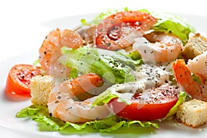 Caesar salad with shrimp close up on white background