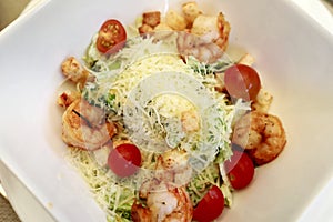 Caesar salad with shrimp on white plate