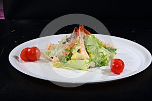 Caesar salad with shrimps on a white plate