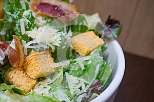 Caesar salad in white bowl image close up.