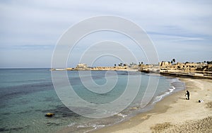 Caesara, Israel - view on fisherman in bay, and port in distance