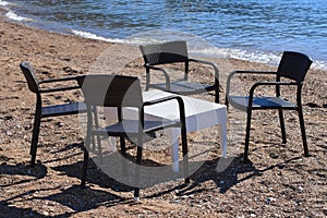 Cafe on the beach: wicker table and chairs by the sea.