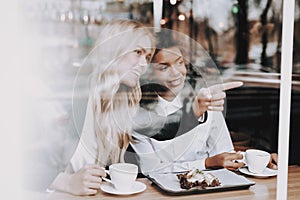 Cafe. Blond Girl. Mulatto. Sit. Drink Coffee.