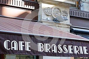 Cafe brasserie french sign text means coffee brewery on entrance restaurant in city street storefront building pub entrance