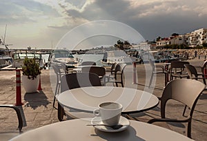 Cafe, empty coffee cup on a table with view of Zygi harbour