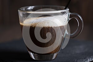 Cafe espresso macchiato layered coffee in a see through glass coffee cup photo