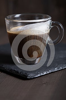 Cafe espresso macchiato layered coffee in a see through glass coffee cup photo