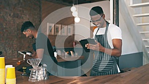 Cafe, happy people and barista on tablet for restaurant teamwork, social media and customer service reviews. Waiter or