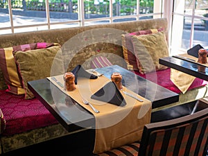 Cafe interior with wooden furniture and bright pillows on the sofa. Nuwara Eliya, Sri Lanka