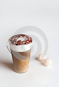 Latte macchiato in a tall glass on a white background. Cafe latte layered with milk in a high drinking glass. photo