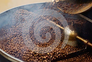 Cafe, mix and coffee beans in a machine for a raw blend, textures and steam in a pot. Food, industry and espresso and
