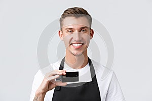 Cafe and restaurants, coffee shop owners and retail concept. Close-up of handsome friendly-looking waiter, salesman