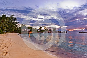 Cafe on Seychelles tropical beach at sunset