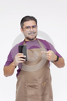 A cafe shop owner or manager pointing to his cellphone. Phone food delivery app or contact details concept. Isolated on white