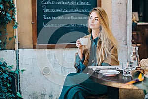 Cafe table young woman drinking coffee lifestyle blackboard background