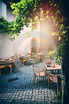 Cafe terrace in small European city at sunny summer day