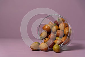 Caferana fruits Bunchosia armeniaca in natura served in a bowl on a pink background photo