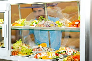 Cafeteria food display young man choose salad