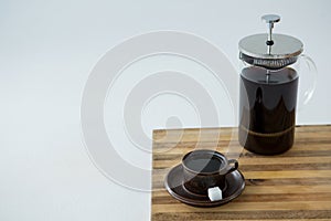 Cafetiere and a cup of black coffee on table