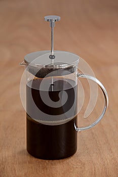 Cafetiere on wooden background photo