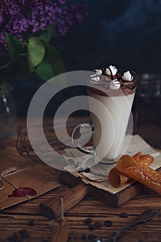 Caffe latte on dark moody background with flowers