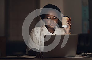 Caffeine and ambition are a powerful combination. a young businesswoman having coffee and using a laptop during a late