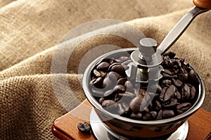 Caffeine rich strong stimulant beverage conceptual idea with detailed close up vintage manual coffee grinder with beans full of