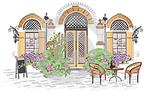 CafÃ© entrance decorated with flowers and greenery.