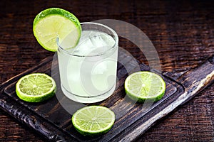 Caipirinha cocktail in glass on wooden table background. Copyspace, bar menu image, international caipirinha day, 13th September