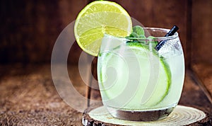 Caipirinha cocktail in glass on wooden table background. Copyspace, international caipirinha day, 13th September