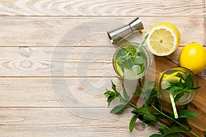 Caipirinha, Mojito cocktail, vodka or soda drink with lime, mint and straw on table background. Refreshing beverage with