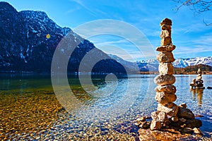 A cairn  human-made pile or stack of stones near Hallstatt lake at sunny day in Austrian Alps
