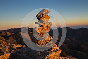 Cairn with mountains in the background at sunset photo