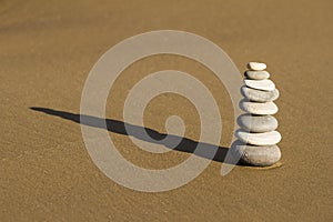 Cairn of rounded rocks on wet beach sand