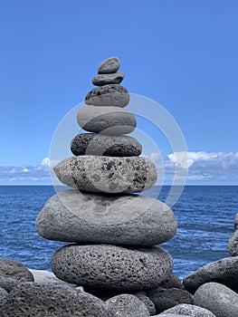 cairn on the shore against the blue sky close-up, balance