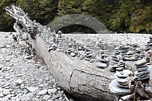 Cairns on a dead tree in the riverbed of Haast River
