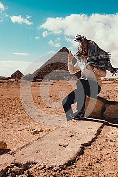 Cairo Egypt December 2021 Adult man posing wearing a traditional scarf with the great pyramids of giza in the background