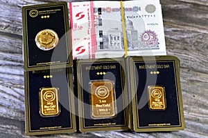 Cairo, Egypt, December 8 2023: 24K karat BTC Bullion Trading Center pure yellow gold of bars and sovereign coin, and a stack of
