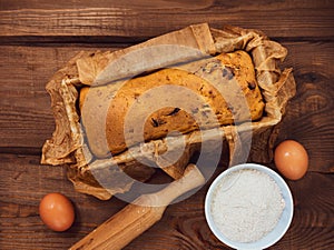 Cake in baking mold with rolling pin rural rustic wooden background flat lay. Pastry dough recipe ingredients with eggs