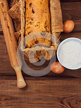 Cake in baking mold with rolling pin rural rustic wooden background flat lay. Pastry dough recipe ingredients with eggs