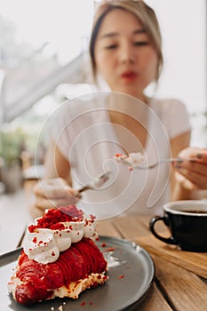 Cake being eat by woman in the cafe. Focus selective on the cake.