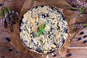 Cake with blueberry decorated with mint on wooden table. Breakfast morning table