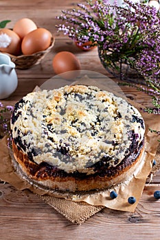 Cake with blueberry decorated with mint on wooden table. Breakfast morning table