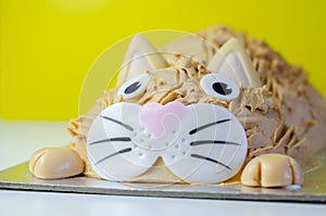 Cake cat,madeira sponge, layered and coated with caramel flavour frosting, finished with edible sugar decorations