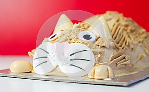 Cake cat,madeira sponge, layered and coated with caramel flavour frosting, finished with edible sugar decorations