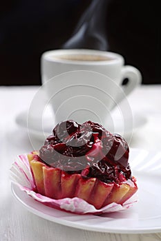 Cake with cherry and cup of coffee