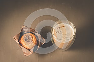 cake with a chocolate stuffing in paper and a cappuccino glass/cake with a chocolate stuffing in paper and a cappuccino glass on a