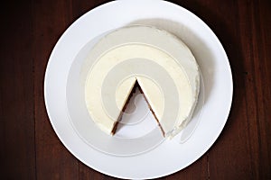 Cake with cream cheese icing, cut and piece missing