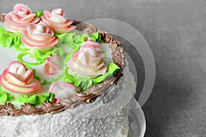 Cake with cream flowers close-up. Celebratory cake on a gray background. Cake decoration