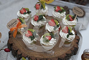 Cake with Cream and Strawberry in a Glass Cup on the Wooden Plate. Snack Bar. Candy Bar. Sweet Dessert.